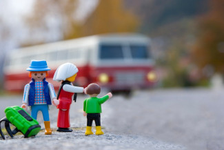 Spielfiguren vor einem Reisebus